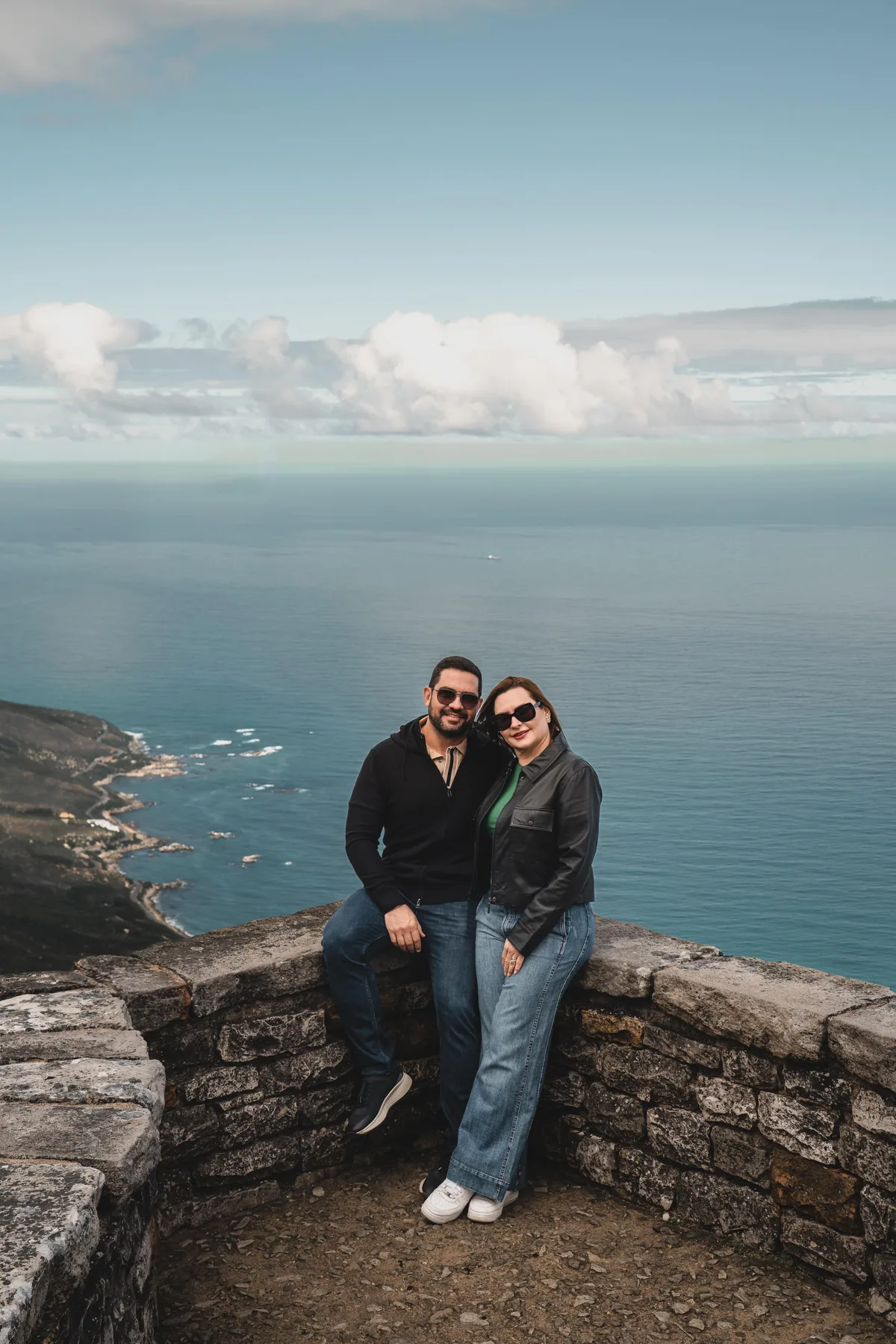 Dois participantes no alto da Table Mountain, com o litoral ao fundo.