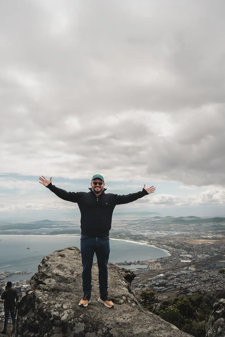 Participante de braços abertos no alto da Table Mountain.