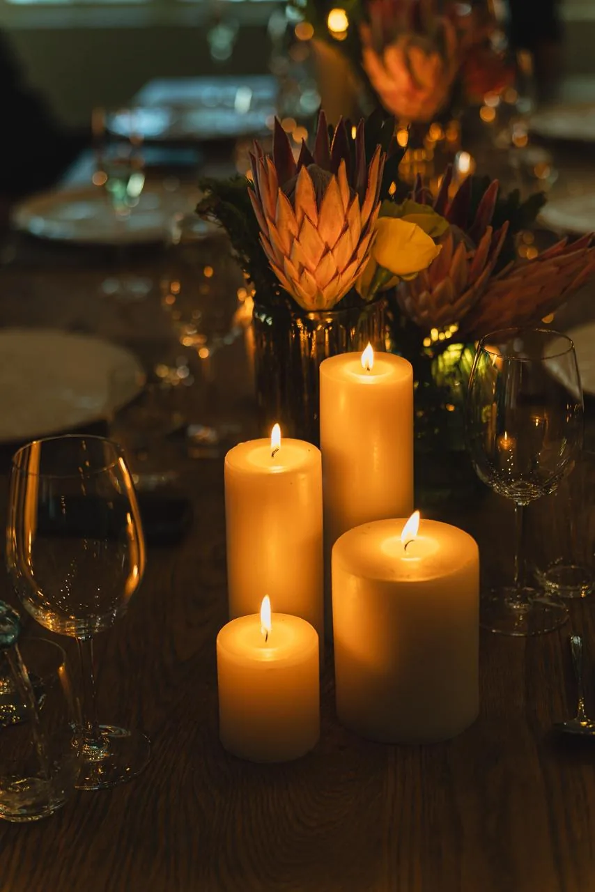 Velas e taças sobre a mesa em La Petite Ferme.