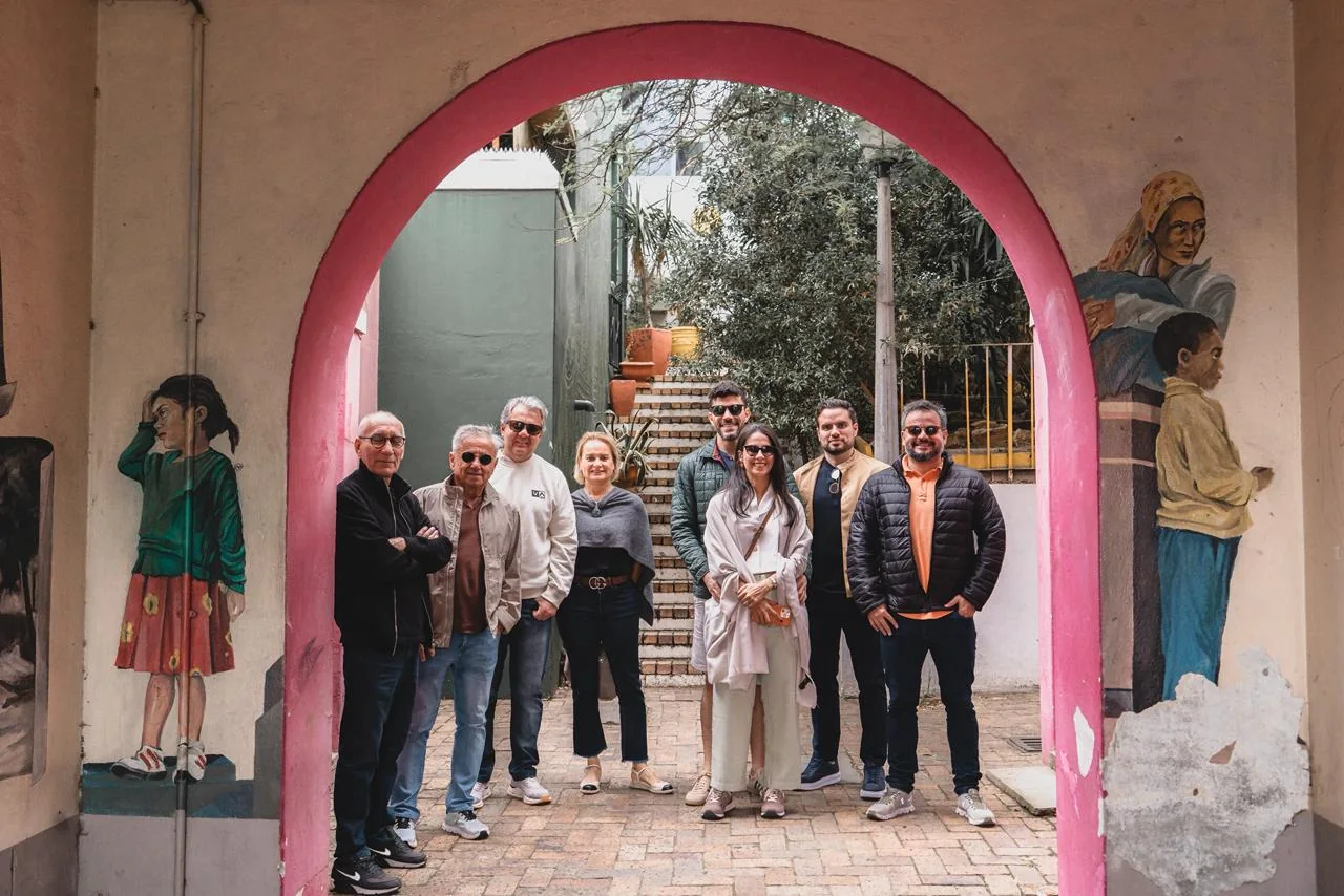 O grupo reunido sob um arco de fachada coral no Bo-Kaap.