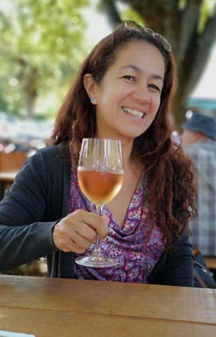 Sonia Freire à mesa, com uma taça de vinho